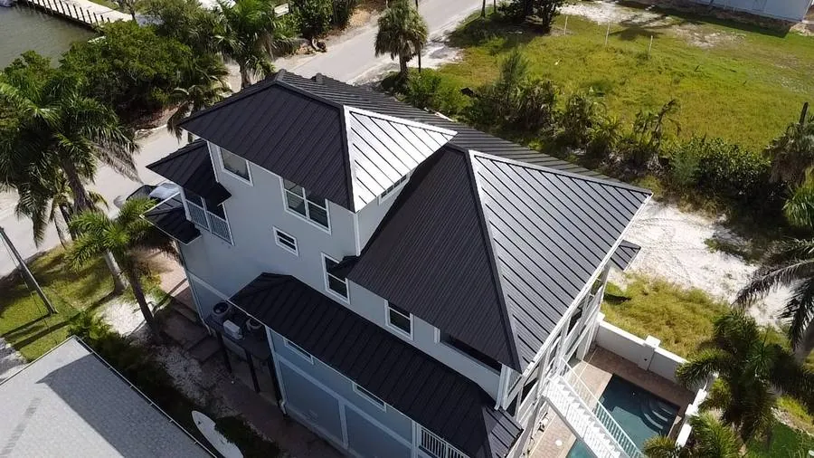 Standing seam metal roof waterfront home Cape Coral FL aerial drone view